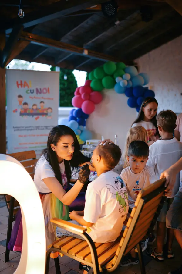 Anca Marinică pictând fața unui copil